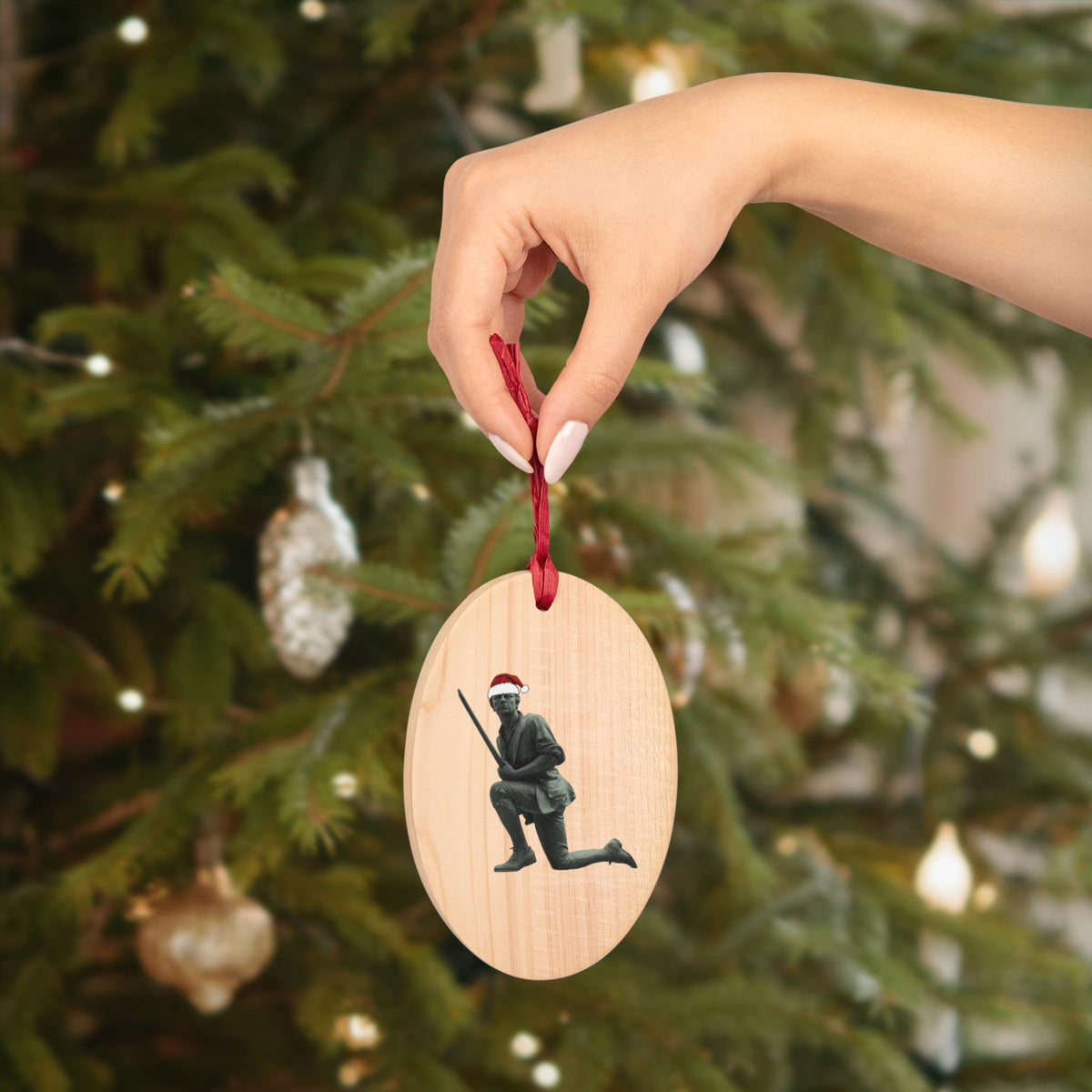 Minuteman wooden ornament hanging on a Christmas tree by its red ribbon — rustic two sided wood ornament