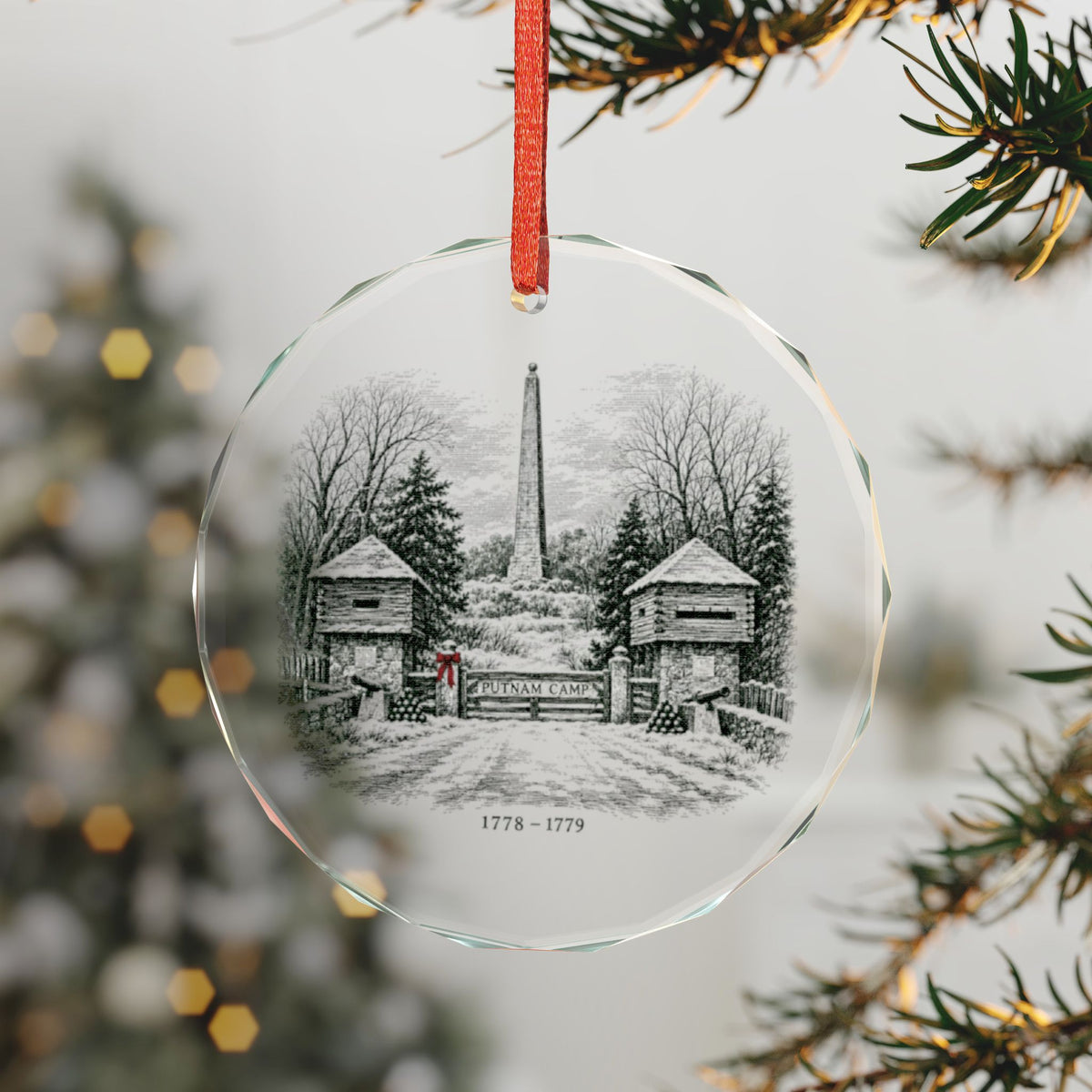 Engraved-Style Winter View of the Putnam Camp Gate, Twin Log Blockhouses, Cannons and the 1888 Monument on a Faceted Crystal Glass Ornament, Hanging on a Christmas Tree with Red Ribbon, Redding, Connecticut