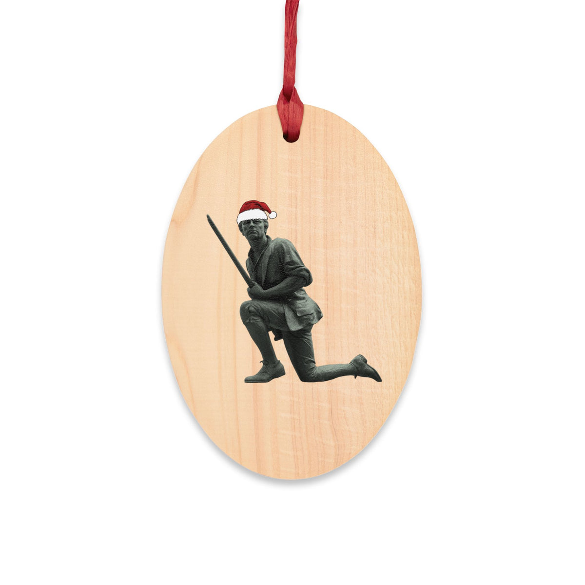 Minuteman wooden ornament, front — kneeling minute man statue with Santa hat printed on natural wood grain oval